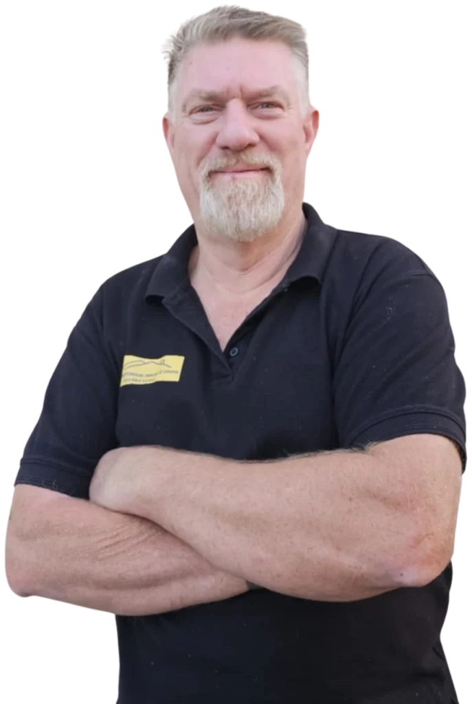 Marc standing with arms crossed from the waist up and looking at the camera.